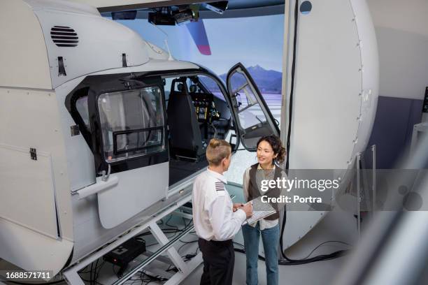 piloto enseñando a una estudiante en la academia de aviación. - simulador de vuelo fotografías e imágenes de stock