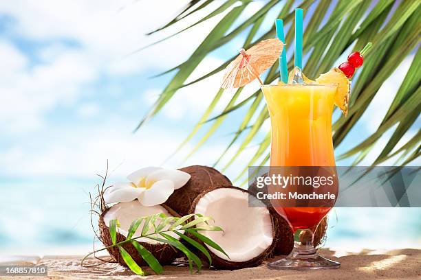 tequila sunrise cóctel en la playa - fruta tropical fotografías e imágenes de stock
