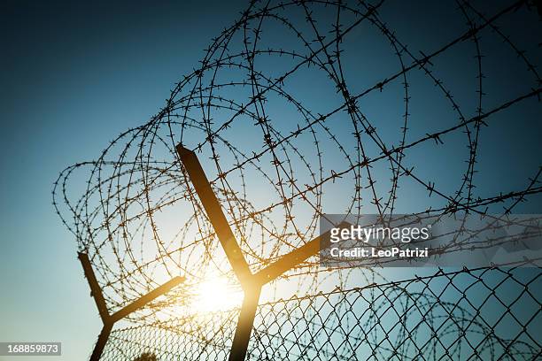 alambradas de púas en prisión - alambrada fotografías e imágenes de stock