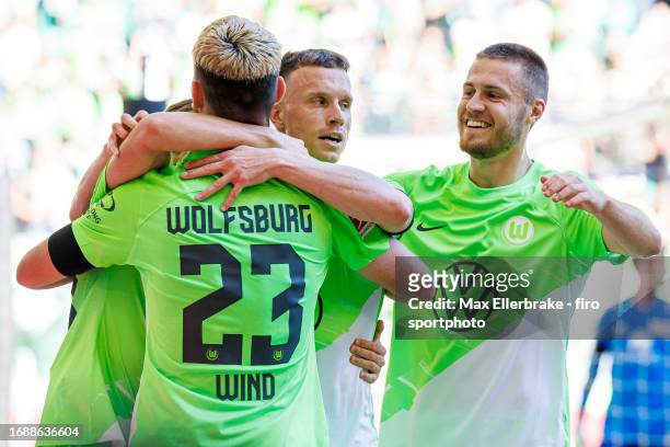 Jonas Wind of VfL Wolfsburg celebrates with teammmates Yannick Gerhardt and Mattias Svanberg after scoring his teams first goal during the Bundesliga...