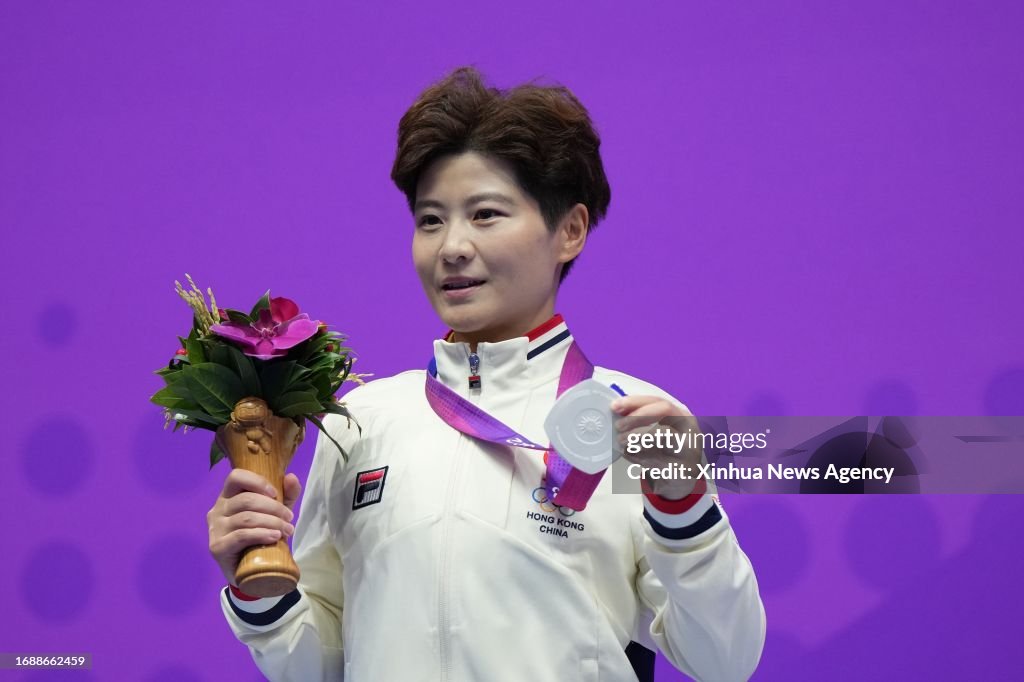 Silver medalist Liu Xuxu of China’s Hong Kong poses for photos during