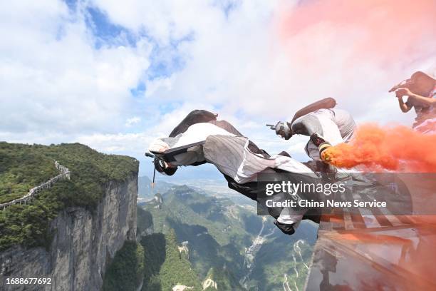 Wingsuiter Mike Hitchcock of the Great Britain jumps from the cliffs as he competes in the precision fly-through competition during the ninth World...