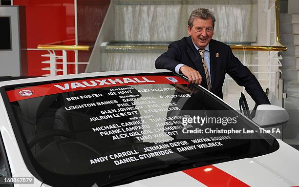 England Manager Roy Hodgson poses beside a Vauxhall Astra with the names of the England squad England squad on the windscreen during a press...