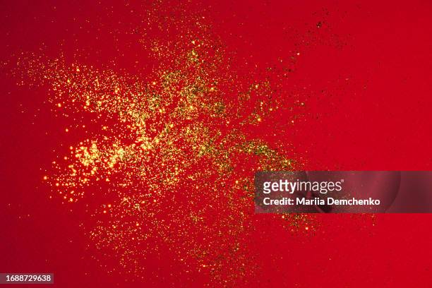red paper with scattered gold glitter - scatter stock-fotos und bilder