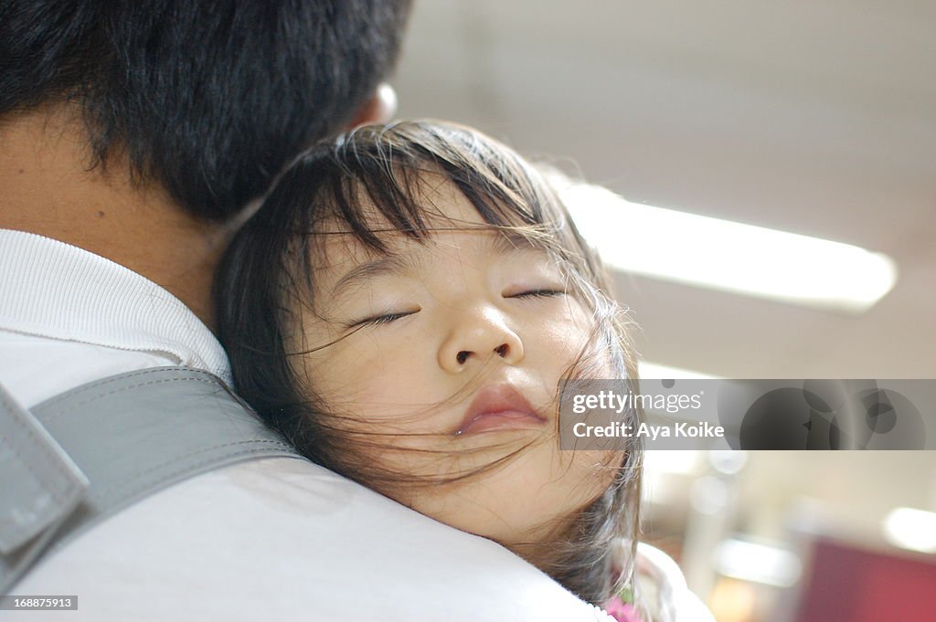 Daddy holding his daughter sleeping