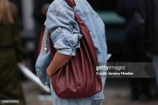 Tiffany Hsu is seen wearing a light blue jeans jacket and a wine-red leather bag from LOEWE during London Fashion Week September 2023 before the...