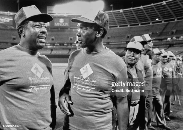 Baseball legends Hank Aaron and Ernie Banks talk about old times during a brief ceremony honoring the black living legends of Negro League baseball...