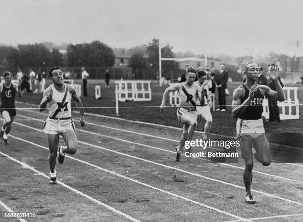 American athlete Jesse Owens crossing the finish line in the 100 yard race at the Big Ten Track and Field Championships at Ferry Field in Ann Arbor,...