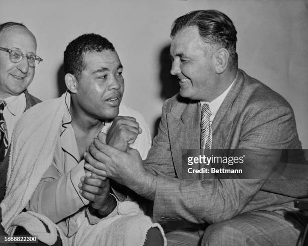 Former Boxer James Braddock renews his acquaintance with the fist of Joe Louis at a training camp in Pompton Lakes, New Jersey, September 20th 1950....