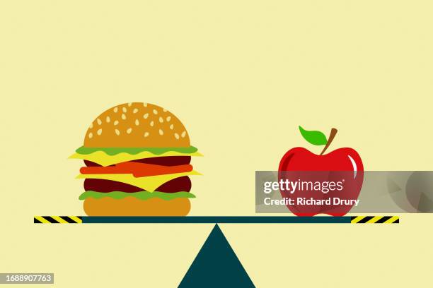 a burger and an apple on a seesaw - freshness icon stock pictures, royalty-free photos & images