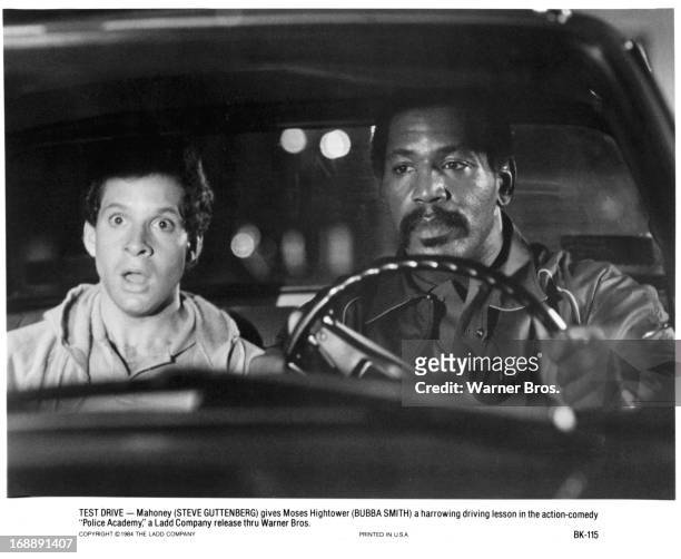 Steve Guttenberg rides with Bubba Smith in a scene from the film 'Police Academy', 1984.