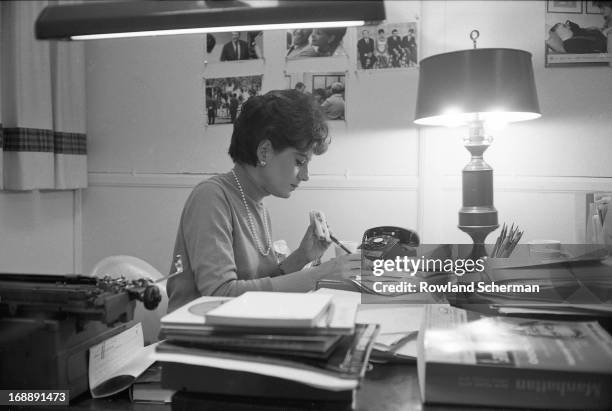 American broadcast journalist Barbara Walters eats a sandwich as she works at her desk, New York, New York, 1966.