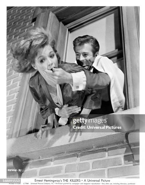 Angie Dickinson is threatened with death at the hands of Clu Gulager in a scene from the film 'The Killers', 1964.