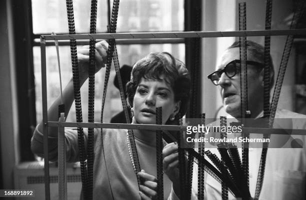 American broadcast journalist Barbara Walters looks at film negatives with an unidentified man behind the scenes at NBC Studios, New York, New York,...