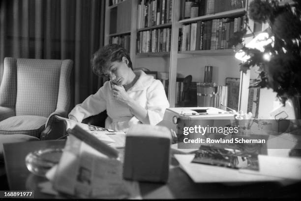 American broadcast journalist Barbara Walters wears as bathrobe as she speaks on the telephone and reads a newspaper in her home, New York, 1966.