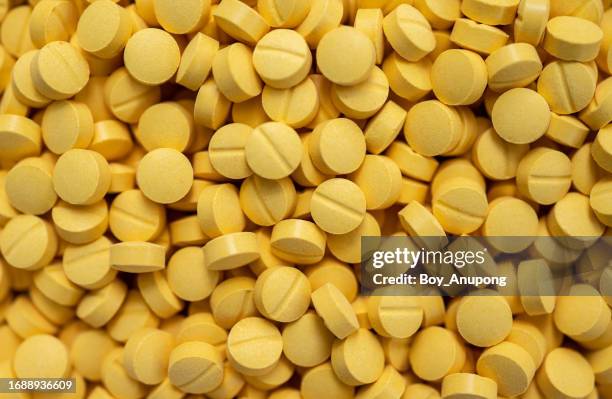 full frame shot of yellow pills. medicines are chemicals or compounds used to cure, halt, or prevent disease. - pharmaceutical factory stock pictures, royalty-free photos & images