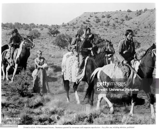 Abby Dalton is taken hostage by Henry Silva in a scene from the film 'The Plainsman', 1966.