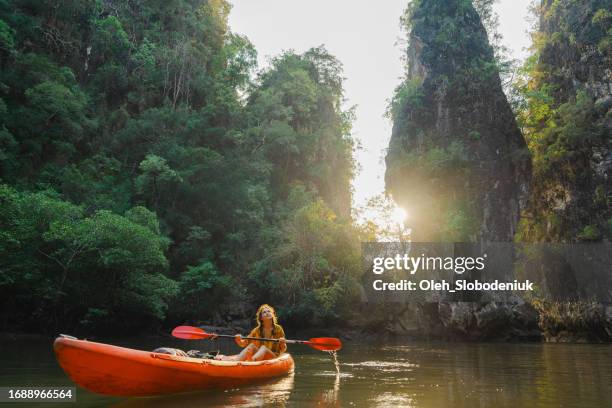 cheerful woman sea kayaking among karst formations and mangrove forest on krabi - exoticism stock pictures, royalty-free photos & images