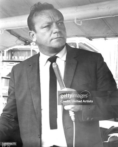 Aldo Ray holds a microphone in a scene from the film 'Kill A Dragon', 1967.