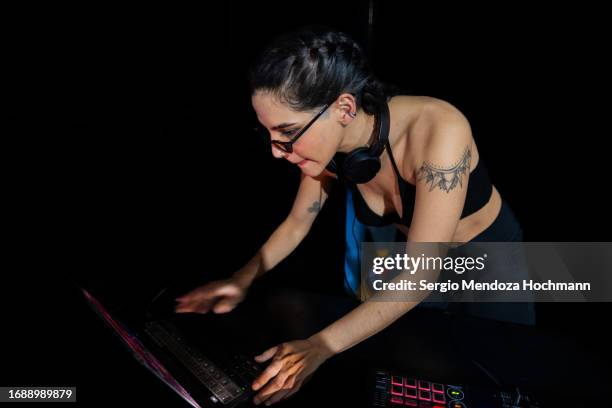 young female latino dj mixing music at night looking at her laptop with sunglasses on - dj portrait ストックフォトと画像