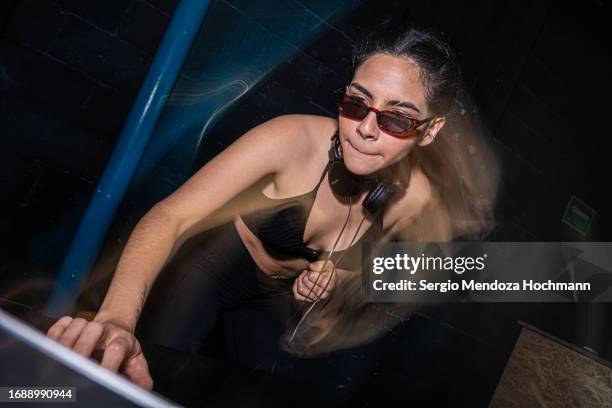 young female latino dj mixing music at night looking at her laptop with sunglasses on - black dj stock pictures, royalty-free photos & images