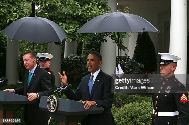 Marines hold umbrellas over U.S. President Barack Obama and Prime Minister Recep Tayyip Erdogan of Turkey as they speak to the media in the Rose...