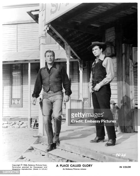 Lex Barker and Pierre Brice on a porch in a scene from the film 'A Place Called Glory', 1965.