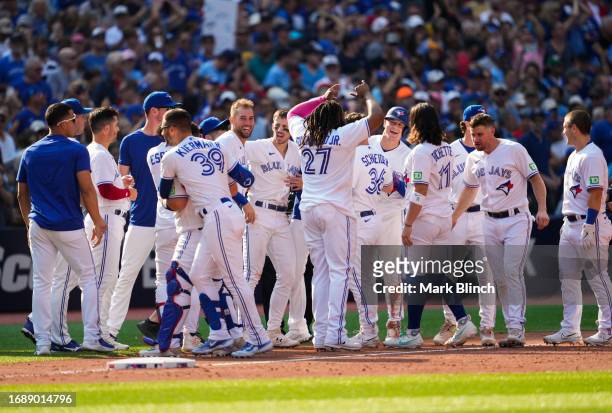 Matt Chapman of the Toronto Blue Jays is mobbed by teammates after hitting a walk off RBI double to defaet the Boston Red Sox during the ninth inning...
