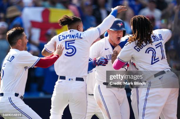 Matt Chapman of the Toronto Blue Jays is mobbed by teammates after hitting a walk off RBI double to defaet the Boston Red Sox during the ninth inning...