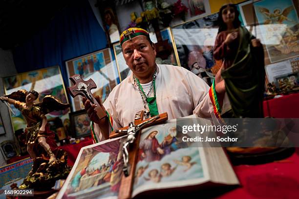 Hermes Cifuentes, a Colombian spiritual healer, prays at an altar in his apartment before performing a ritual of exorcism on 28 May 2012 in La...