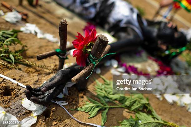 Diana R., who claims to be possessed by spirits, lies on the ground surrounded by crosses and flowers during a ritual of exorcism performed by Hermes...