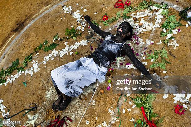 Diana R., who claims to be possessed by spirits, lies on the ground surrounded by flowers after a ritual of exorcism performed by Hermes Cifuentes on...