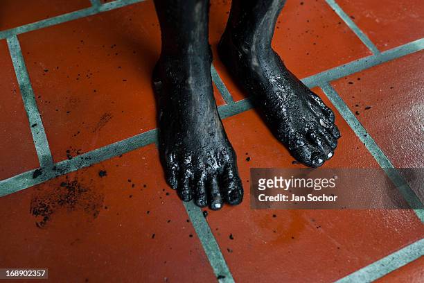 Feet of Diana R., who claims to be possessed by spirits, seen covered by black mud before a ritual of exorcism performed by Hermes Cifuentes on 28...