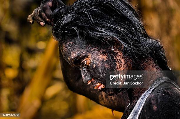 Diana R., who claims to be possessed by spirits, remains covered by black mud after a ritual of exorcism performed by Hermes Cifuentes on 28 May 2012...