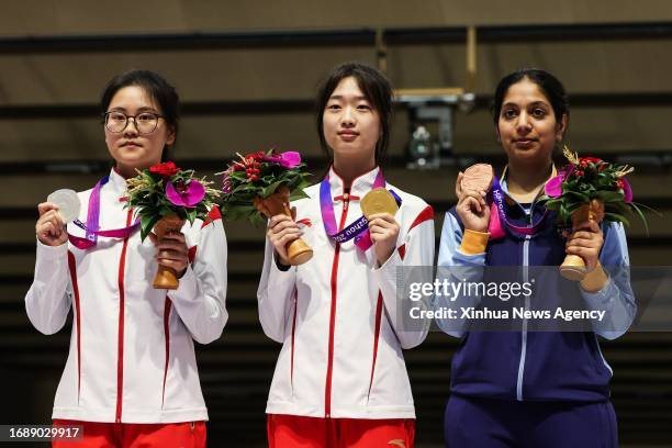 Han Jiayu L, Huang Yuting C of China and Ramita of India pose for photos during the awarding ceremony for the Shooting 10m Air Rifle Women's Final at...