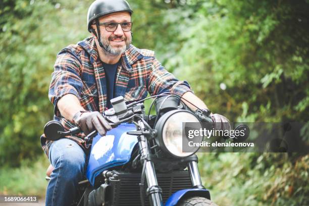 man seat on the motorcycle - single cylinder motorcycle stock pictures, royalty-free photos & images