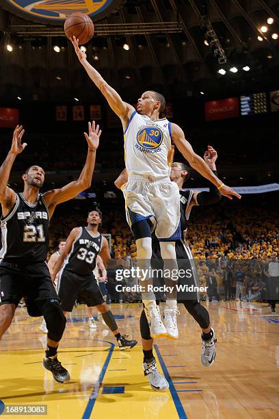 Stephen Curry of the Golden State Warriors shoots against Tim Duncan of the San Antonio Spurs in Game Six of the Western Conference Semifinals during...