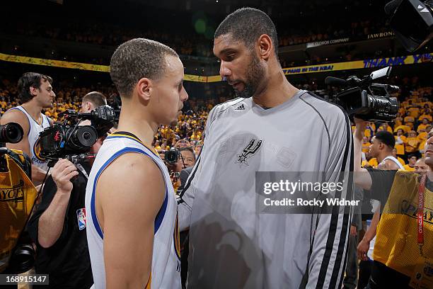 Stephen Curry of the Golden State Warriors talks with Tim Duncan of the San Antonio Spurs after Game Six of the Western Conference Semifinals during...