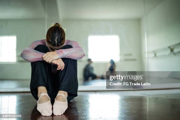 sad young woman at the dance studio - unfair competition stock pictures, royalty-free photos & images