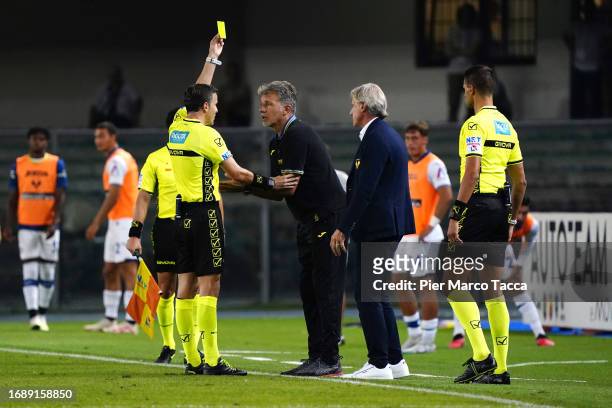 Referee Federico La Penna shows a yellow card to Head Coach of Hellas Verona Marco Baroni during the Serie A TIM match between Hellas Verona FC and...