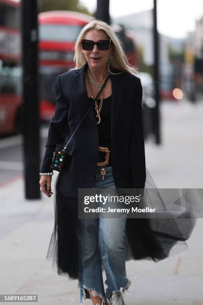 Corina Mihaila Larpin seen wearing a black and white striped long Monse Jaket, Stefere golden jewelry, golden pendant necklace and a golden belt from...