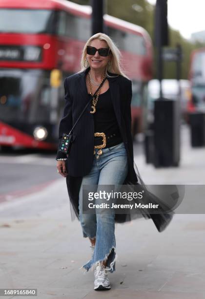 Corina Mihaila Larpin seen wearing a black and white striped long Monse Jaket, Stefere golden jewelry, golden pendant necklace and a golden belt from...