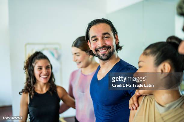 portrait of a mid adult man embrace his friends at the dance studio - equality act stock pictures, royalty-free photos & images