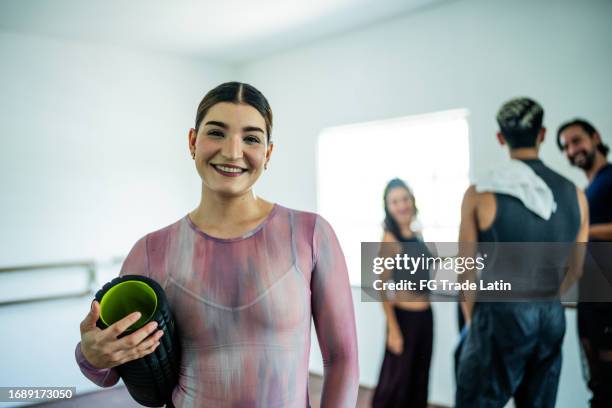 portrait of a young woman at the dance studio - rolled up yoga mat stock pictures, royalty-free photos & images