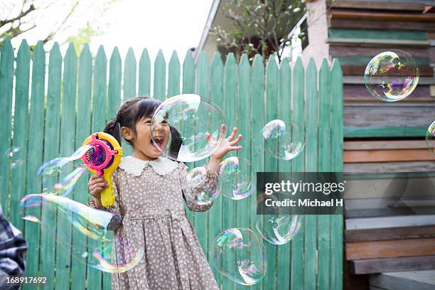 young girl  blowing bubbles outdoor - bubble wand foto e immagini stock