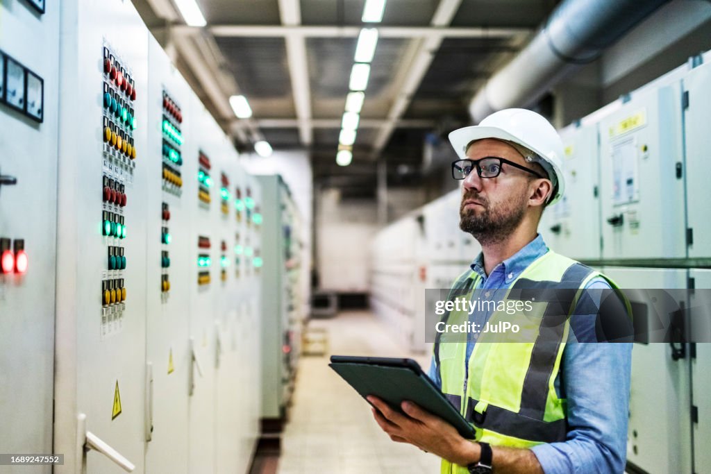 Checing Power Electrical Engineer Checking Power At Control Room Using Digital Tablet ...