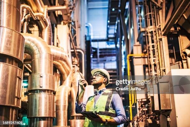 electrical engineer examining electric power station using digital tablet and walkie-talkie - district heating stock pictures, royalty-free photos & images