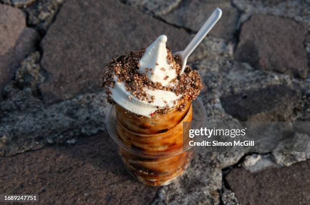 chimney cake made with berry jam and soft serve ice cream and sprinkles - trdelník stock pictures, royalty-free photos & images