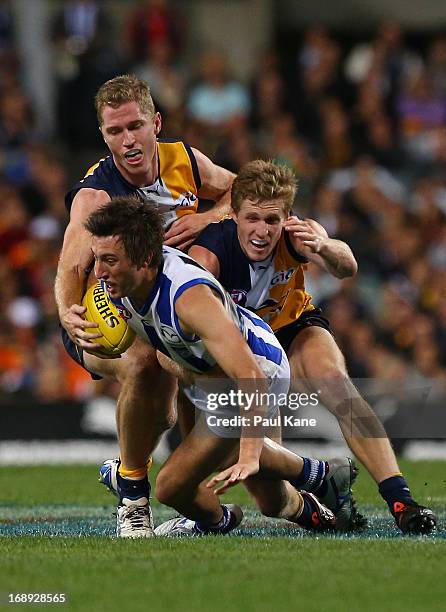 Sam Wright of the Kangaroos gets tackled by Scott Selwood and Adam Selwood of the Eagles during the round eight AFL match between the West Coast...