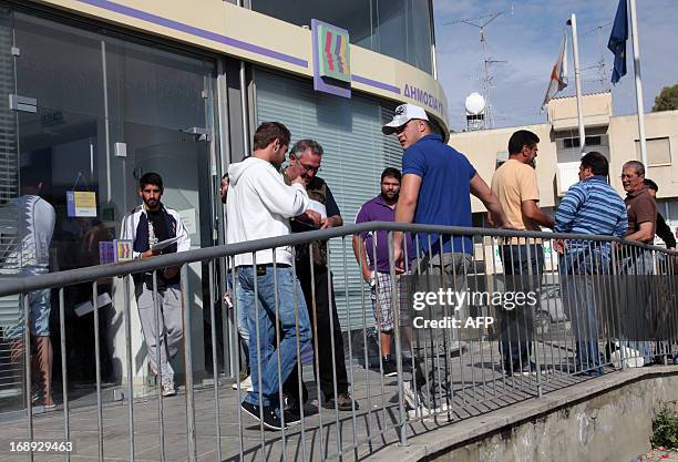 Unemployed people wait outside the Cypriot government's Labour office on May 14, 2013 in the Aglangia district of Nicosia, as the east Mediterranean...